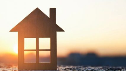 Cutout of a house on a hill with the sun shining through the windows