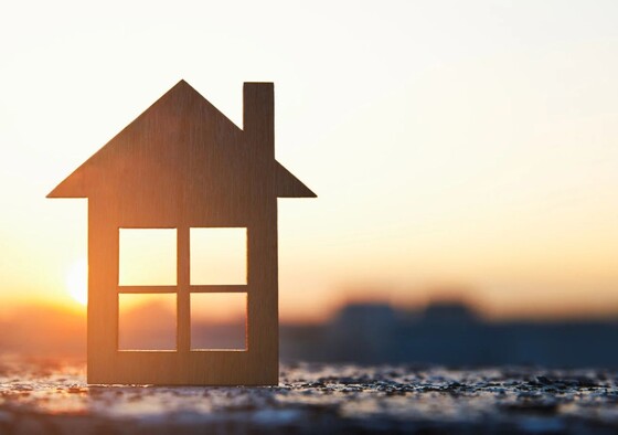 Cutout of a house on a hill with the sun shining through the windows