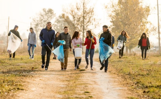 Group of people walking down a path cleaning trash