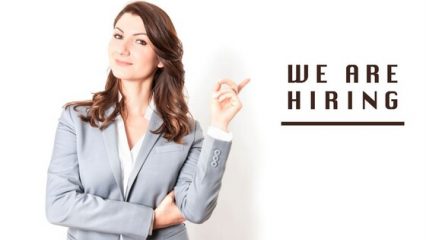 Woman in suit pointing to the words "We Are Hiring"