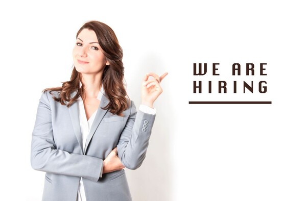 Woman in suit pointing to the words "We Are Hiring"