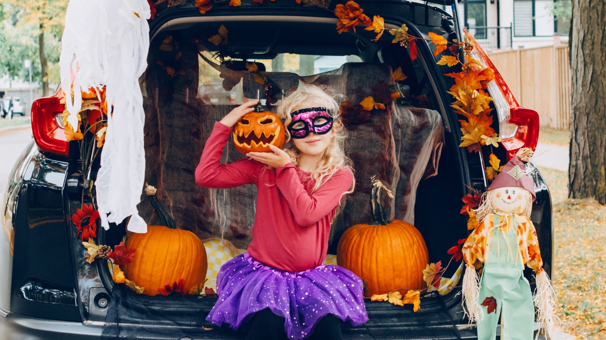 Photo of girl with mask in trunk of car.