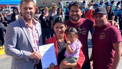 Policy Advisor Christopher Porter presents a certificate to Olympic Flame Burgers