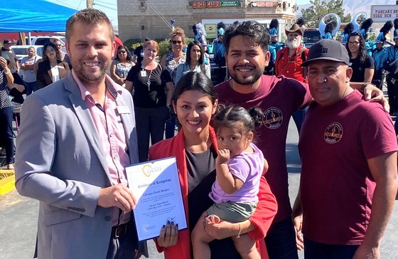 Policy Advisor Christopher Porter presents a certificate to Olympic Flame Burgers