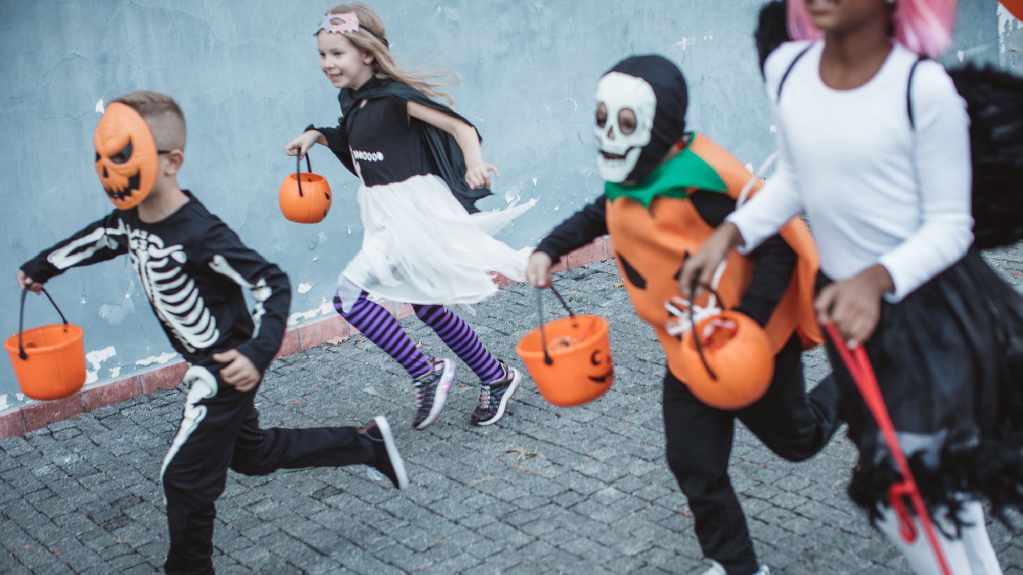 Children with costumes and pumpkin buckets