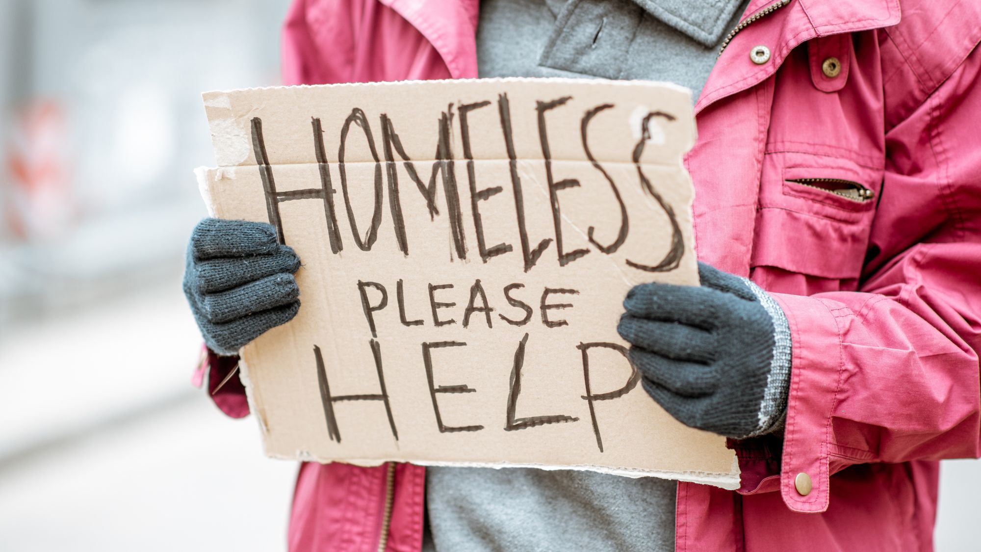 Photo of homeless person holding sign that says "HOMELESS Please Help."