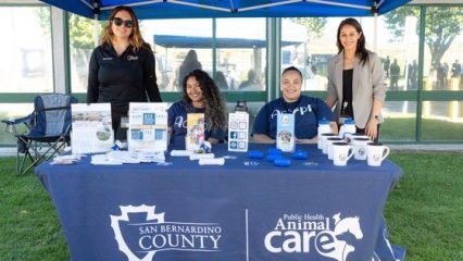 Four employees of San Bernardino County Animal Care with pamphlets at a table.