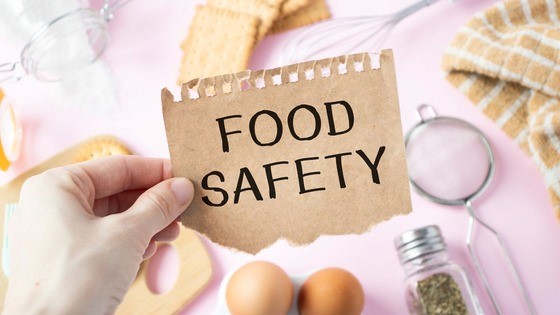 Person holding paper that says "Food Safety"