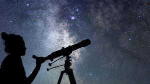 Woman looking through telescope