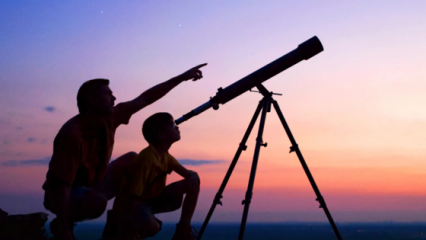 father and son looking through telescope