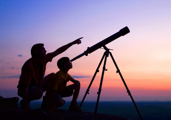 father and son looking through telescope