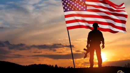 Soldier at sunset with American flag