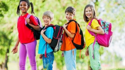 Four kids wearing backpacks