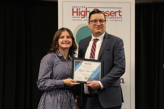 Dakota Higgins presents a scholarship to a student