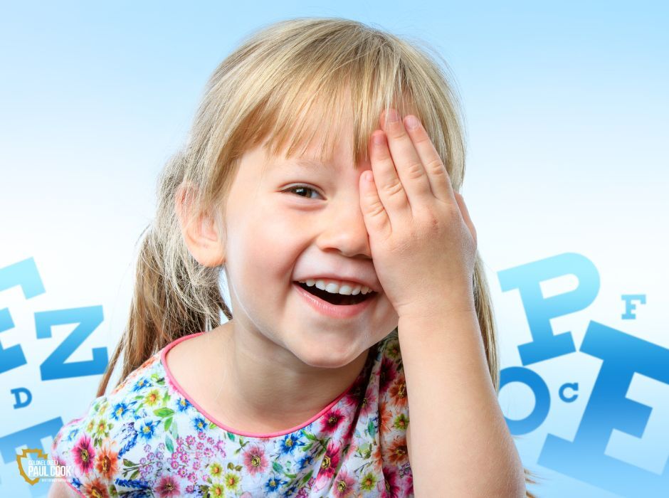 Child holding one hand over her eye.