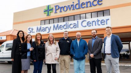 Group photo of Cook's staff and St. Mary staff in front of hospital.